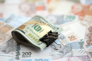 Bir sürü Amerikan doları büyük miktarda Brezilya banknotunun üzerinde yatar. Amerika 'nın parası Brezilya' nın para akışına bağlı. Brezilya 'da ekonomi ve döviz kuru kavramı
