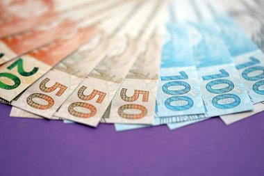 Brezilya reais para banknotlarını mor masaya büyük miktarda koy. Brezilya 'nın gerçek para birimleri. Finans ve bankacılık kavramı