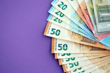 Avrupa para birimi banknotlarının büyük bir kısmı mor renkli masaya yakın. Avrupa 'da iş ve gelir kavramı