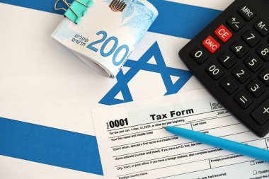 İsrail 'in yeni şekeri, hesap makinesi ve bayraktaki vergi formuyla para basıyor. Şu anki İsrail parası ve vergileri yakın plan. İsrail 'de vergi ödeme ve muhasebe kavramı