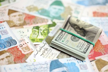 Bir sürü Amerikan doları Pakistan Rupileri 'nin banknotlarına yakın duruyor. Amerikan para demeti Pakistan 'ın para banknotlarında yatıyor. Pakistan 'da ekonomi ve döviz kuru kavramı