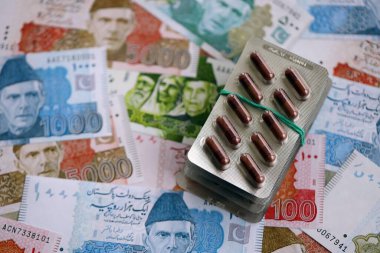 Pakistan banknotları ve ilaç hapları. Pakistan 'ın mevcut para ve uyuşturucu faturaları büyük miktarda masada yatıyor. Pakistan 'da ilaç ve eczane kavramı