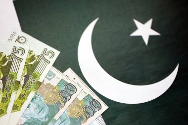 Pakistan 'ın bayrak geçmişi üzerine Pakistan banknotları. Pakistan 'ın mevcut para faturaları büyük miktarlarda pankartta yatıyor. Pakistan 'da ekonomi ve ticaret kavramı
