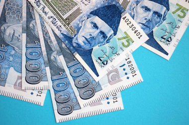 Pakistan banknotları mavi arka planda. Pakistan 'ın mevcut para faturaları büyük miktarda masada yatıyor. Pakistan 'da iş ve yatırım kavramı