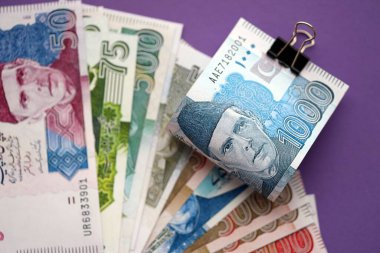 Pakistan mor arka planda banknotlar halinde. Pakistan 'ın mevcut para faturaları büyük miktarda masada yatıyor. Pakistan 'da iş ve yatırım kavramı