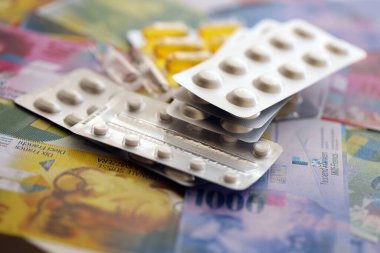 İsviçre frangı ve ilaç hapları. Mevcut para ve uyuşturucu banknotları büyük miktarda masada yatıyor. İsviçre 'de ilaç ve eczane kavramı