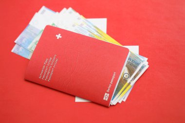 İsviçre frangı banknotları ve bayrak üzerinde biletleri olan pasaport. Mevcut para faturaları ve biyometrik geçiş bayrağın üzerinde. İsviçre 'de seyahat ve tatil kavramı