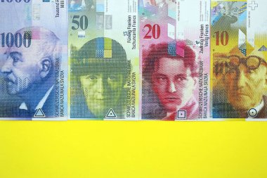 Sarıya İsviçre frangı banknotları. Mevcut frank para faturaları büyük miktarda masada yatıyor. İsviçre 'de iş ve yatırım kavramı