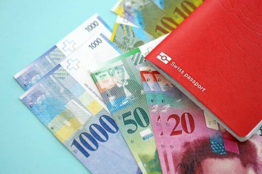 İsviçre frangı banknotları ve mavi üzerine pasaport. Mevcut para banknotları mavi üzerine kuruludur. İsviçre 'de iş ve yatırım kavramı
