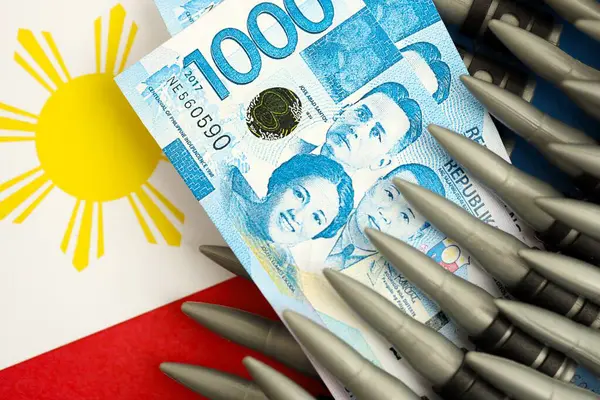 Filipinler para birimi banknotları ve bayraklar üzerinde tüfek mermileri. Savaş ve silah satışı kavramı