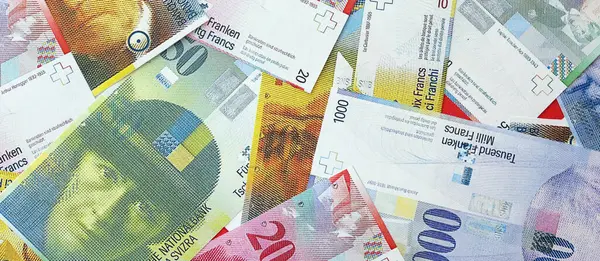 İsviçre frangı banknotları. Mevcut frank para faturaları büyük miktarda masada yatıyor. İsviçre 'de iş ve yatırım kavramı