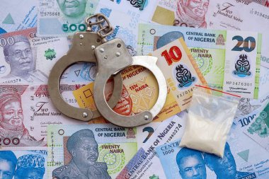 Nijerya naira para birimi faturaları ve kelepçeli kokain paketi. Uyuşturucu suçları kavramı