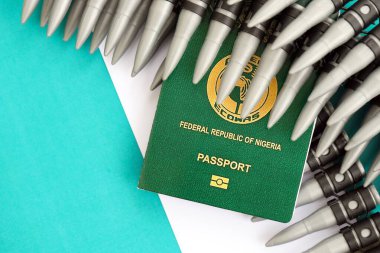 Nijerya pasaportu ve bayraktaki tüfek mermileri. Savaş ve silah satışı kavramı