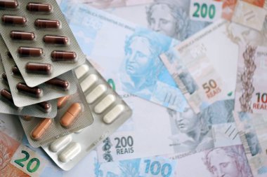 Brezilya bankaları ve ilaç hapları. Mevcut Brezilya gerçek para ve uyuşturucu banknotları büyük miktarda masada yatıyor. Brezilya 'da ilaç ve eczane kavramı