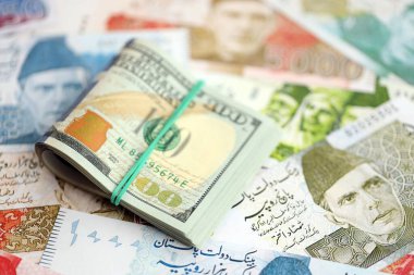 Bir sürü Amerikan doları Pakistan Rupileri 'nin banknotlarına yakın duruyor. Amerikan para demeti Pakistan 'ın para banknotlarında yatıyor. Pakistan 'da ekonomi ve döviz kuru kavramı