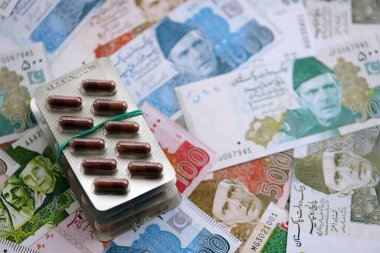 Pakistan banknotları ve ilaç hapları. Pakistan 'ın mevcut para ve uyuşturucu faturaları büyük miktarda masada yatıyor. Pakistan 'da ilaç ve eczane kavramı