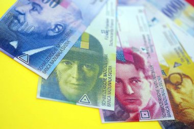 Sarıya İsviçre frangı banknotları. Mevcut frank para faturaları büyük miktarda masada yatıyor. İsviçre 'de iş ve yatırım kavramı