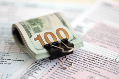 Masada 1040 bireysel gelir vergisi iadesi formuyla birlikte büyük miktarda Amerikan doları banknotları var. ABD 'de vergilendirme ve muhasebe kavramı