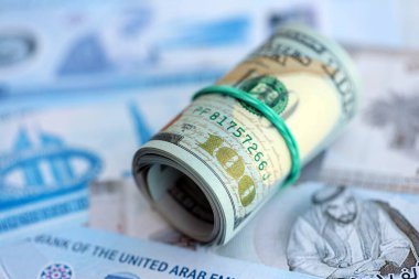 Birleşik Arap Emirlikleri kara para birimi faturaları ve biz dolar banknotları yakın yakın. Ekonomi ve döviz kuru kavramı