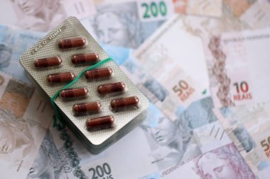 Brezilya bankaları ve ilaç hapları. Mevcut Brezilya gerçek para ve uyuşturucu banknotları büyük miktarda masada yatıyor. Brezilya 'da ilaç ve eczane kavramı