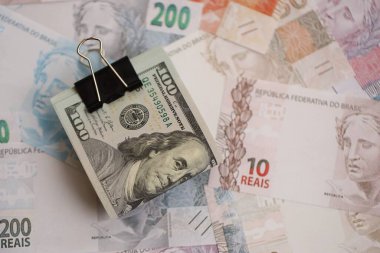 Bir sürü Amerikan doları büyük miktarda Brezilya banknotunun üzerinde yatar. Amerika 'nın parası Brezilya' nın para akışına bağlı. Brezilya 'da ekonomi ve döviz kuru kavramı