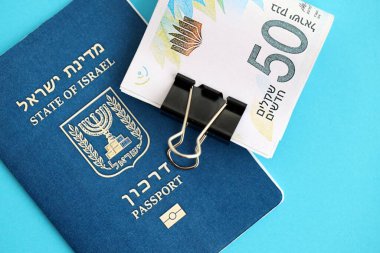 Israel New Shekels banknotları ve mavi arka planda pasaport. İsrail 'in şu anki para banknotları büyük oranda mavi üzerine yatar. İsrail 'de finans ve nakit kavramı
