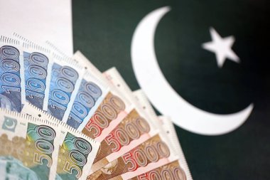 Pakistan 'ın bayrak geçmişi üzerine Pakistan banknotları. Pakistan 'ın mevcut para faturaları büyük miktarlarda pankartta yatıyor. Pakistan 'da ekonomi ve ticaret kavramı