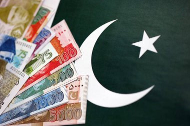 Pakistan 'ın bayrak geçmişi üzerine Pakistan banknotları. Pakistan 'ın mevcut para faturaları büyük miktarlarda pankartta yatıyor. Pakistan 'da ekonomi ve ticaret kavramı