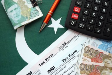 Pakistan hesap makinesi ve vergi formuyla banknotlar halinde. Şu anki Pakistan gerçek para ve vergi faturaları yakın plan. Pakistan 'da vergi ödeme ve muhasebe kavramı