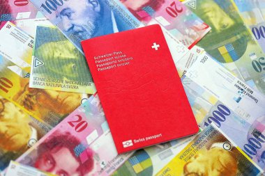 İsviçre frangı banknotları ve pasaportu. Mevcut banknotlar ve biyometrik geçiş kartları büyük miktarda masada yatıyor. İsviçre 'de seyahat ve tatil kavramı