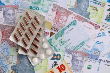Nijerya naira para birimi faturaları ve ilaç hapları yakında. İlaç ve eczane kavramı