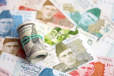 Amerikan dolarlarının rulosu Pakistan 'daki büyük miktardaki banknotların üzerinde yatıyor. Amerikan para demeti Pakistan 'ın para banknotlarında yatıyor. Pakistan 'da ekonomi ve döviz kuru kavramı