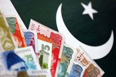 Pakistan 'ın bayrak geçmişi üzerine Pakistan banknotları. Pakistan 'ın mevcut para faturaları büyük miktarlarda pankartta yatıyor. Pakistan 'da ekonomi ve ticaret kavramı