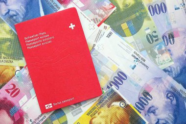İsviçre frangı banknotları ve pasaportu. Mevcut banknotlar ve biyometrik geçiş kartları büyük miktarda masada yatıyor. İsviçre 'de seyahat ve tatil kavramı