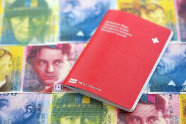 İsviçre frangı banknotları ve pasaportu. Mevcut banknotlar ve biyometrik geçiş kartları masanın üzerinde. İsviçre 'de seyahat ve tatil kavramı