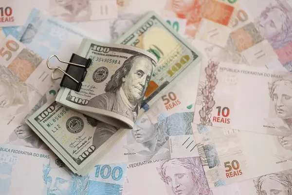 Bir sürü Amerikan doları büyük miktarda Brezilya banknotunun üzerinde yatar. Amerika 'nın parası Brezilya' nın para akışına bağlı. Brezilya 'da ekonomi ve döviz kuru kavramı