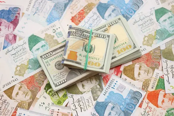 Amerikan dolarları yığını Pakistan Rupi banknotlarının büyük bir miktarına yakın duruyor. Amerikan para demeti Pakistan 'ın para banknotlarında yatıyor. Pakistan 'da ekonomi ve döviz kuru kavramı
