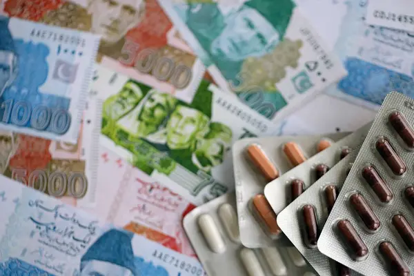 Pakistan banknotları ve ilaç hapları. Pakistan 'ın mevcut para ve uyuşturucu faturaları büyük miktarda masada yatıyor. Pakistan 'da ilaç ve eczane kavramı