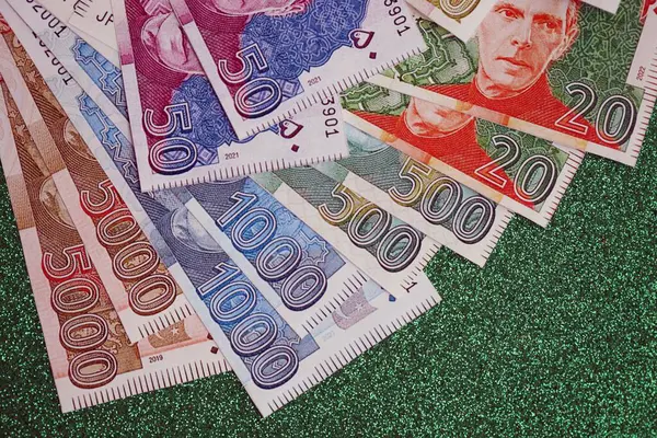 Pakistan parlayan yeşil arka planda banknotlar halinde. Pakistan 'ın mevcut para faturaları büyük miktarda masada yatıyor. Pakistan 'da iş ve yatırım kavramı