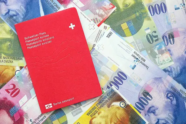 İsviçre frangı banknotları ve pasaportu. Mevcut banknotlar ve biyometrik geçiş kartları büyük miktarda masada yatıyor. İsviçre 'de seyahat ve tatil kavramı