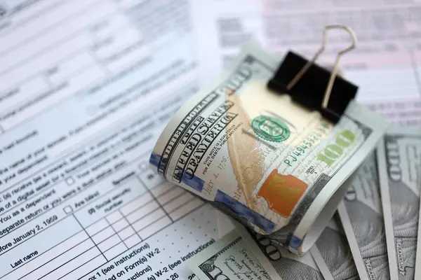 Masada 1040 bireysel gelir vergisi iadesi formuyla birlikte büyük miktarda Amerikan doları banknotları var. ABD 'de vergilendirme ve muhasebe kavramı