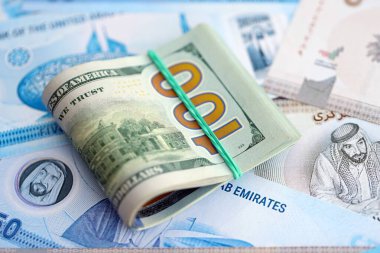 Birleşik Arap Emirlikleri kara para birimi faturaları ve biz dolar banknotları yakın yakın. Ekonomi ve döviz kuru kavramı