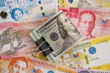 Filipinler Peso para birimi faturaları ve biz dolar banknotları yakın. Ekonomi ve döviz kuru kavramı