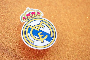 KYIV, UKRAINE - 23 Şubat 2025 Real Madrid CF futbol kulübü rozeti altın sarısı parıltılı arka plan pankartıyla uzanır