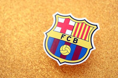 KYIV, UKRAINE - 23 Şubat 2025 FC Barcelona futbol kulübü rozeti altın sarısı parıltılı arka plan pankartıyla uzanır