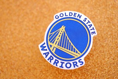 KYIV, UKRAINE - 23 Şubat 2025 Golden State Warriors basketbol takımı rozeti altın sarısı parıltılı arka plan pankartıyla uzanır