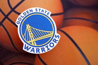 KYIV, UKRAINE - 23 Şubat 2025 Golden State Warriors basketbol takımı rozeti basketbol topu arka plan pankartıyla yatar