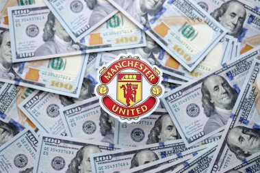 KYIV, UKRAINE - 23 Şubat 2025 Manchester United FC futbol kulübü rozeti büyük miktarlarda Amerikan doları üzerinde yer almaktadır.