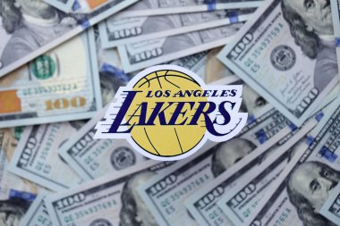 KYIV, UKRAINE - 23 Şubat 2025 Los Angeles Lakers basketbol takımı rozeti yüzlük banknotların üzerinde.