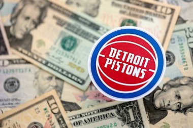 KYIV, UKRAINE - 23 Şubat 2025 Detroit Pistons basketbol takımı rozeti Amerikan dolarlarının büyük miktarına yakın.